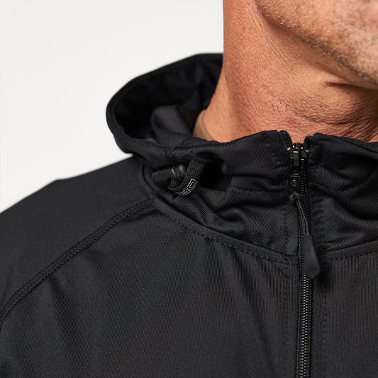 Close-up of a person wearing a black zip-up jacket with a hood. The focus is on the upper section and the jacket's fabric texture.