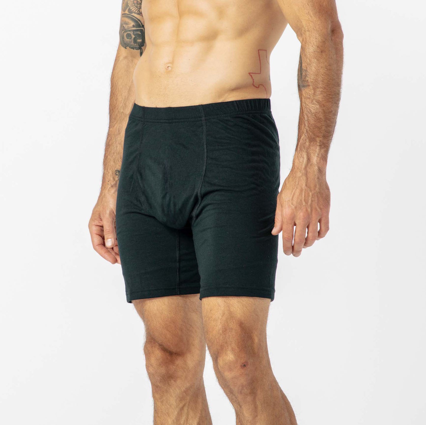 A man wearing black boxer briefs with a visible tattoo.