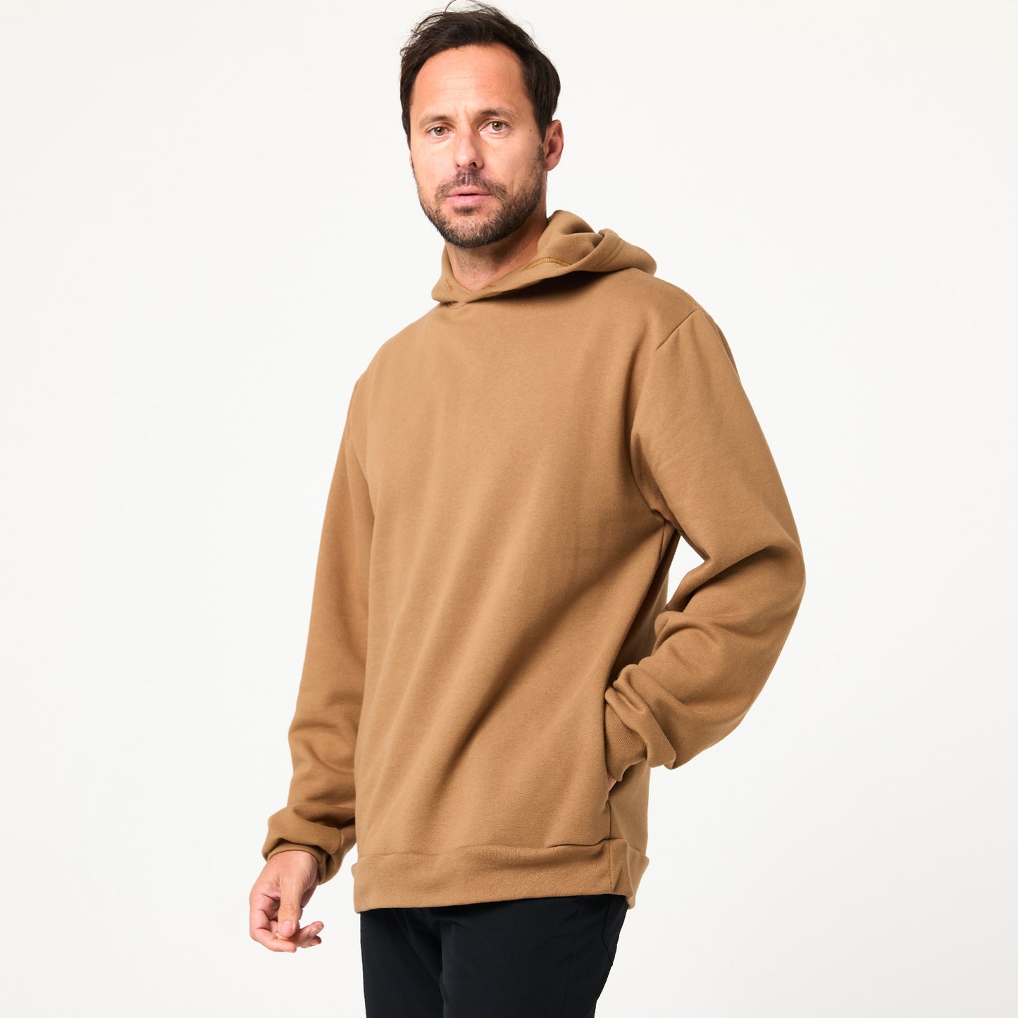 A man in a tan DFND Memphis Fleece Hood and black pants stands against a plain background, facing the camera with a neutral look—perfect for cold weather training.