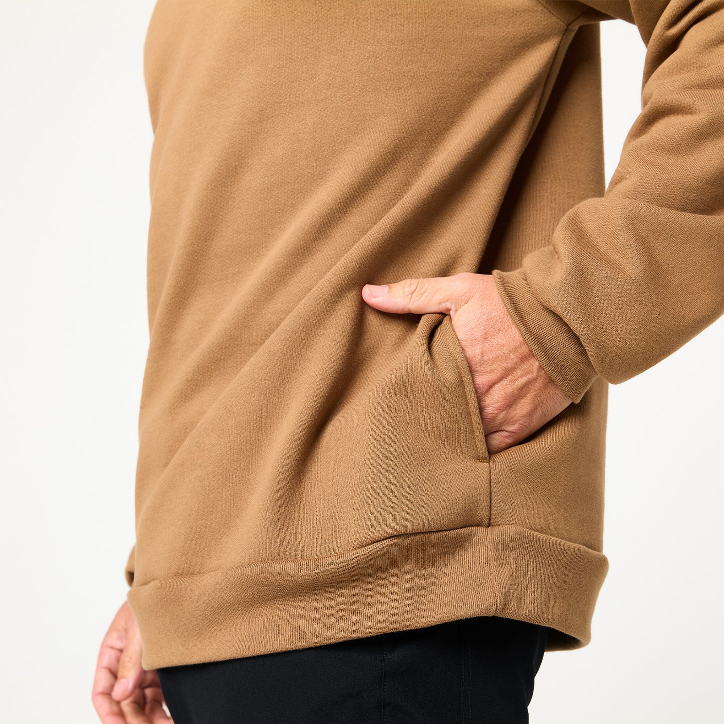 A person wears the DFND Memphis Fleece Hood in brown with their right hand in a side pocket, shown waist to mid-thigh against a plain background—perfect for cold weather training.