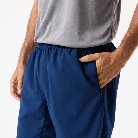 A person wearing a gray shirt and DFND MALIBU 7" PT SHORTS stands with one hand in their pocket against a plain background.