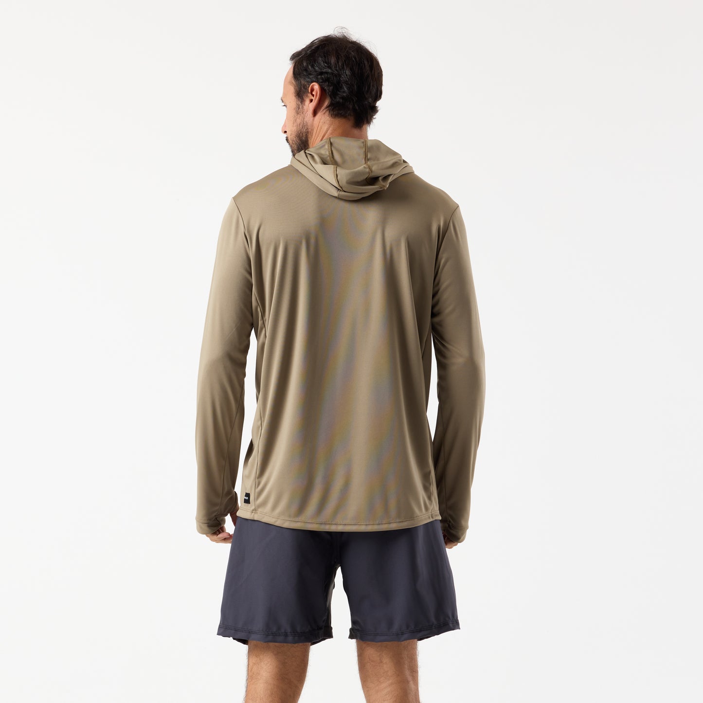 A man faces away, wearing the DFND SPEED TECH HOODED 1/4 ZIP performance shirt with a tan hood and dark shorts, set against a plain white background.