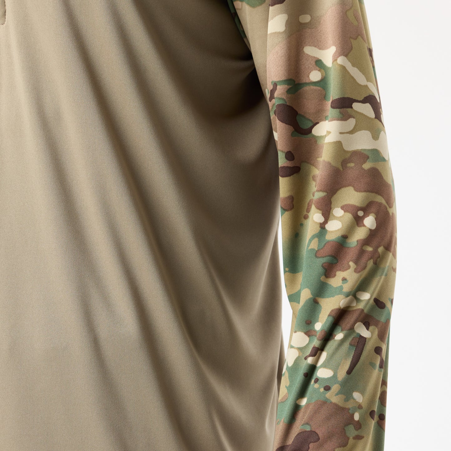 A close-up of a person wearing the DFND SPEED TECH HOODED 1/4 ZIP, featuring a lightweight tan body and a camouflage-patterned sleeve.