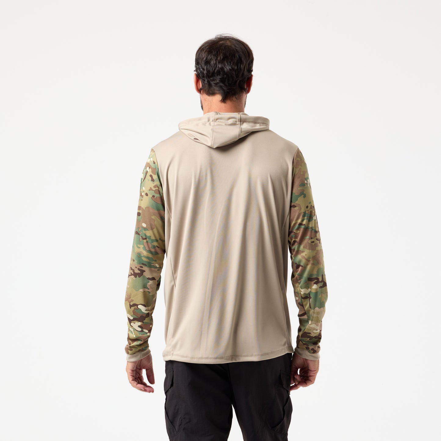 A man faces away in a DFND SPEED TECH HOODED 1/4 ZIP—a tan lightweight performance shirt with camo sleeves—and black pants, set against a plain white background.