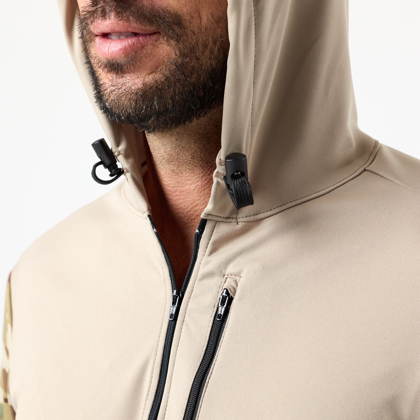 A man wears the DFND SPEED TECH HOODED 1/4 ZIP in beige, shown chin to chest. The lightweight performance jacket features black zippers, a partially raised hood, and visible drawstrings.