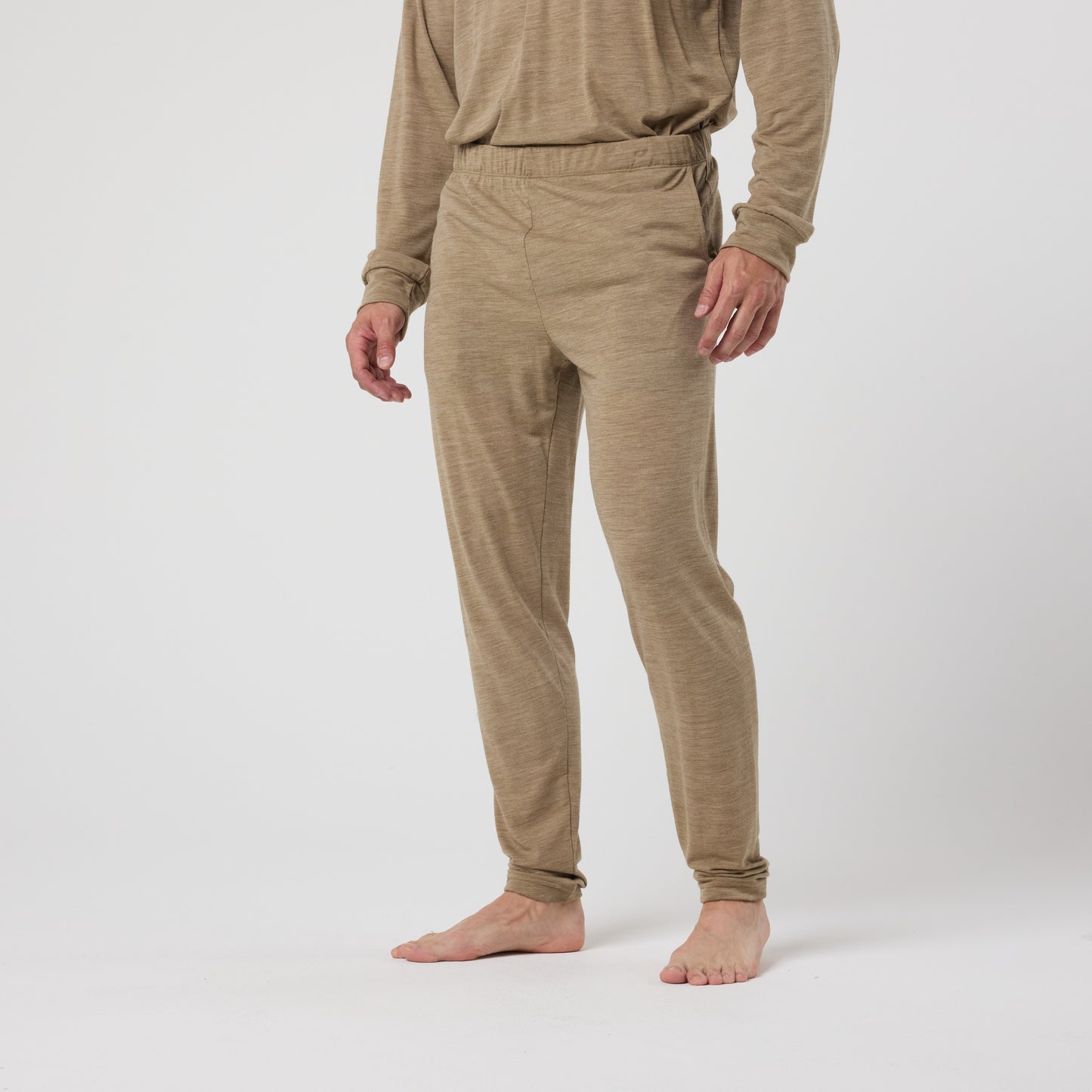 A person stands barefoot in the DFND ASPEN MERINO WOOL LONG JOHN set, shown from shoulders down against a plain white background.
