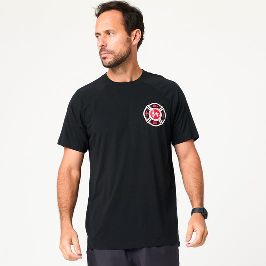 A man wearing a DFND FR SS Men's Performance Shirt with raglan sleeves and a small red and white circular logo on the left chest stands against a plain white background.