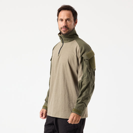 A man wears the DFND FR COMBAT SHIRT in khaki and olive, featuring a chest zipper and sleeve pockets, standing against a plain white background.