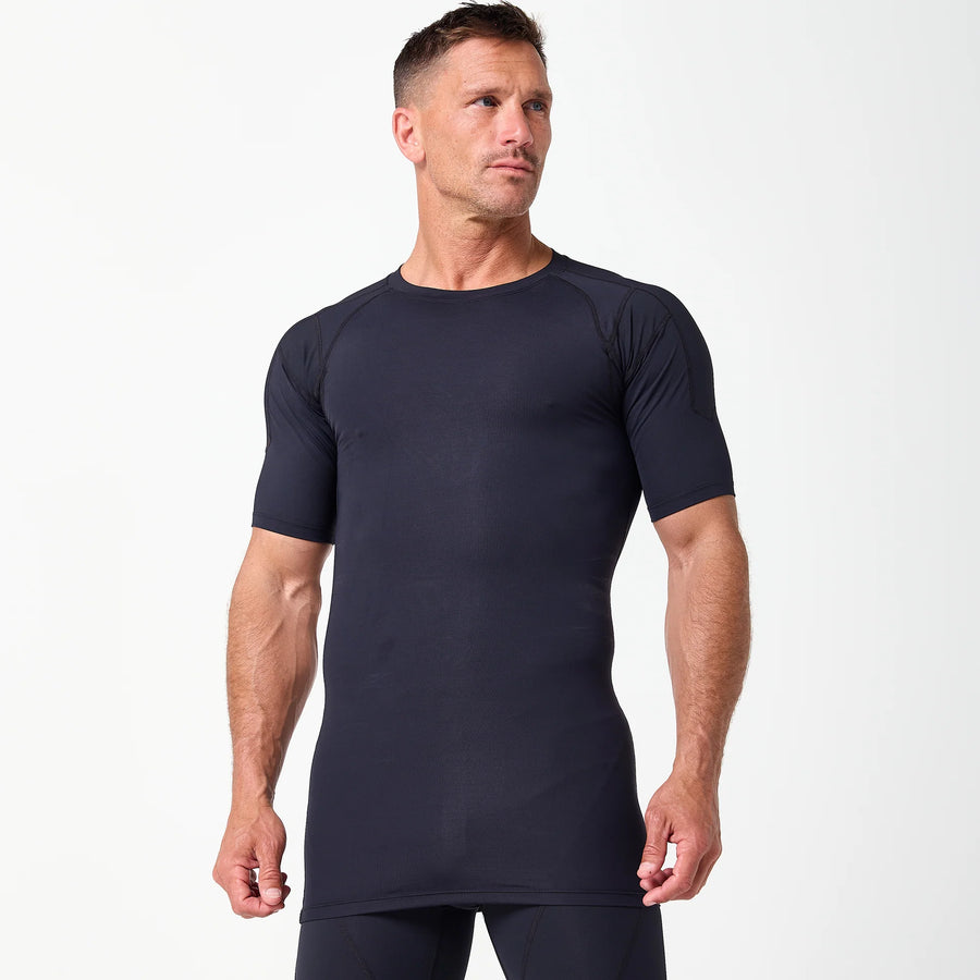 A man models the DFND Compression Short + Shirt Gym Kit, a black fitted athletic set with graduated compression, against a plain white background.